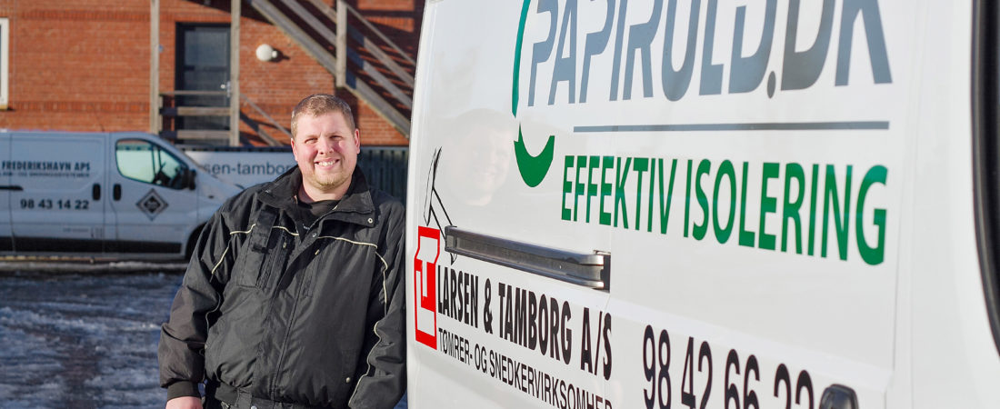 Medarbejder i Larsen og Tamborg A/S poserer foran firmabil